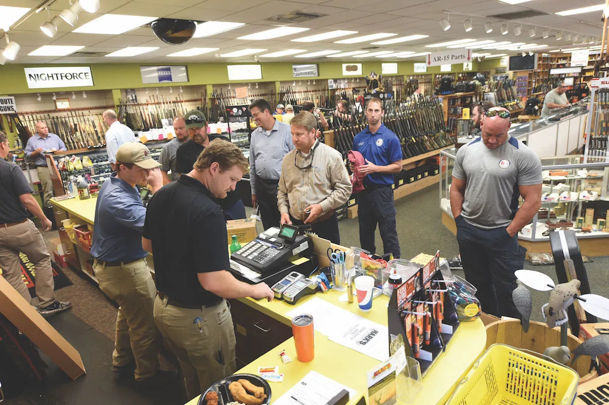 Staff helping customers at the sales counter inside Mark's Outdoors